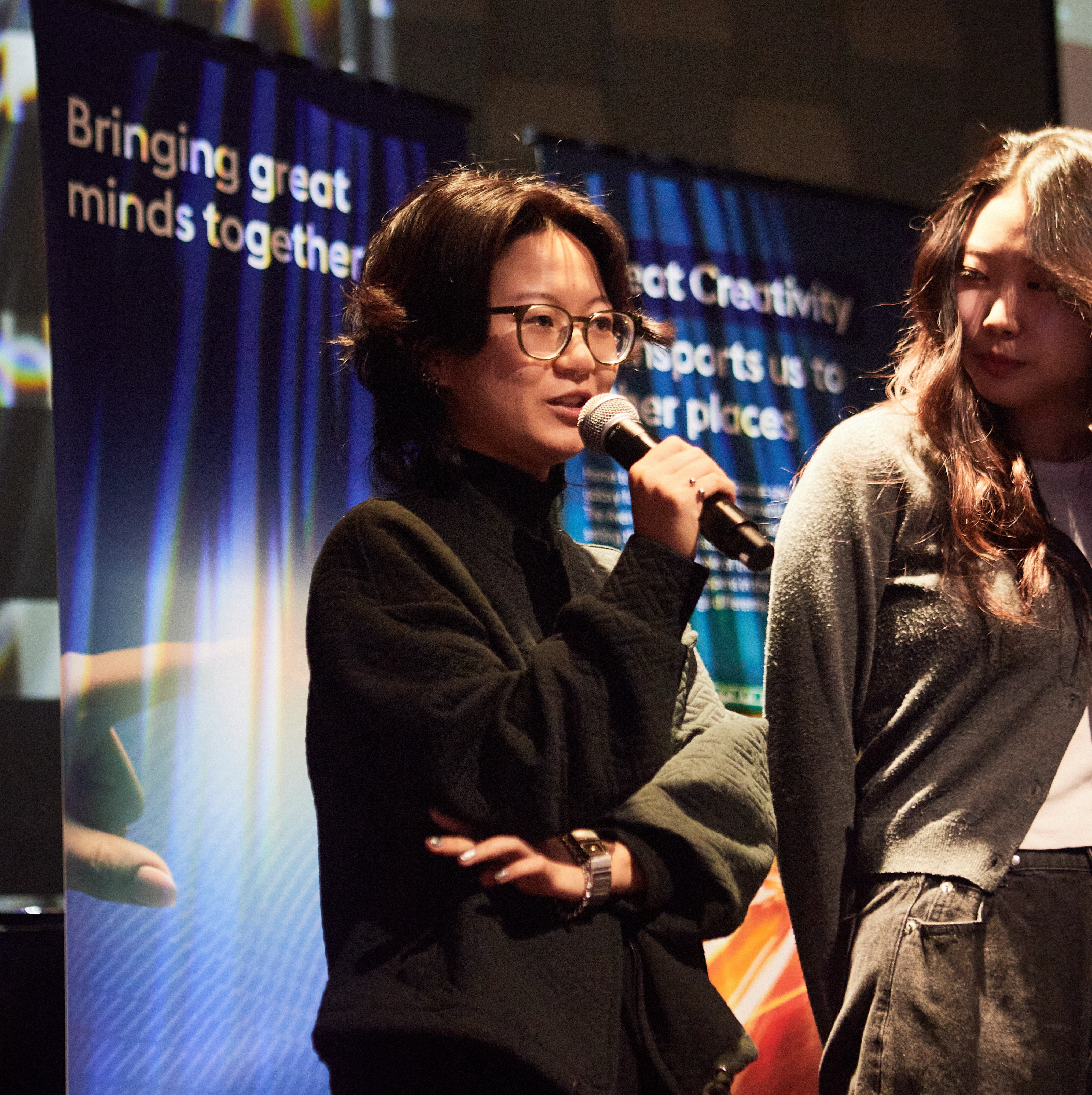 Charlene speaking into a microphone at the showcase